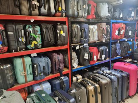 Luggage stored on secure shelves inside the shop