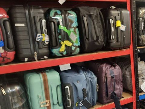 Close-up of tagged suitcases on the storage shelves
